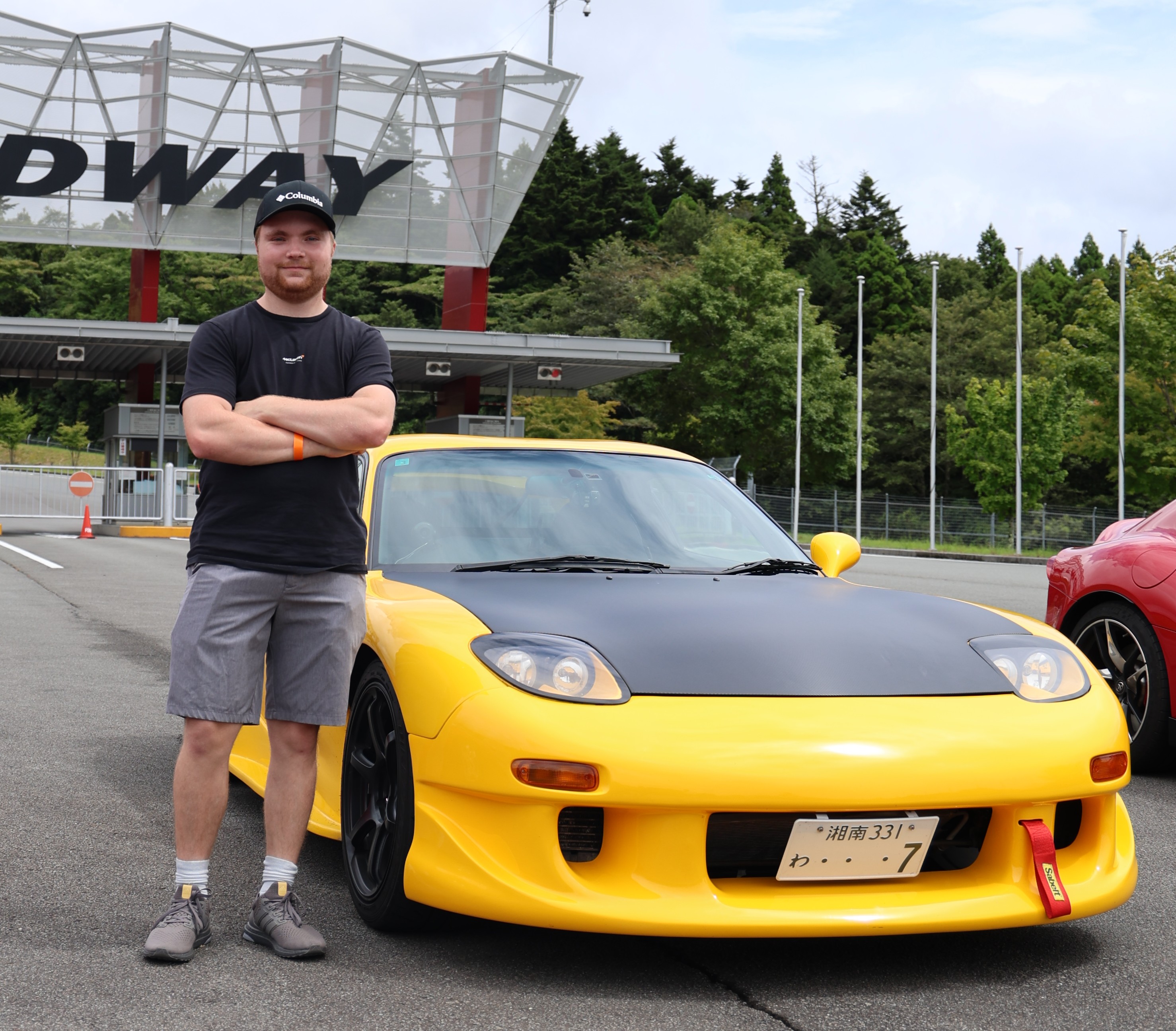 Alan Moody standing with a car at the Fuji Speedway entrance